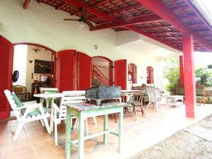 a patio with tables and chairs on a house at Casa com muito lazer a 100m da Praia de Guaeca SP in Barequeçaba