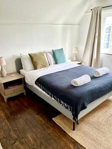 1 dormitorio con 1 cama grande con manta azul en Cooden Cottage en Bexhill