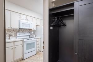 a kitchen with white cabinets and a black door at Suwannee Gables in Old Town