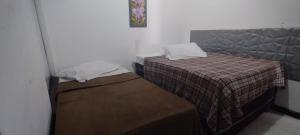 Cette petite chambre comprend deux lits. dans l'établissement HOTEL Al ATLANTICO, à Aracaju