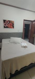 un grande letto bianco con due asciugamani sopra di HOTEL Al ATLANTICO ad Aracaju