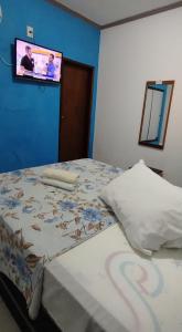 a bedroom with a bed with a tv on the wall at HOTEL Al ATLANTICO in Aracaju