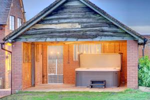 a large shed with a bed and a window at Fairview Cottage - Luxury Cottage with Hot Tub & Pizza Oven in Alvechurch