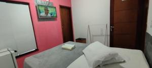 um quarto com uma cama e uma parede rosa em HOTEL Al ATLANTICO em Aracaju