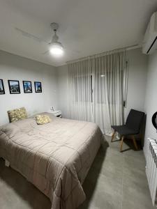 Un dormitorio con una cama grande y una silla. en Departamento Rivadavia, en Santa Fe
