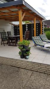 a patio with a gazebo and a table and chairs at Ferienhaus To Huus in Langen