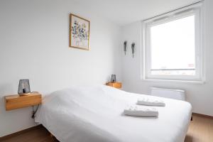 ein weißes Schlafzimmer mit einem großen weißen Bett und einem Fenster in der Unterkunft Le 4K - Vue dégagée, Clim, Gare 10min à pied in Straßburg + 10 Fotos