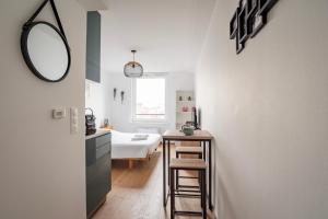 Zimmer mit einem Bett und einem Wandspiegel in der Unterkunft Le 4K - Vue dégagée, Clim, Gare 10min à pied in Straßburg