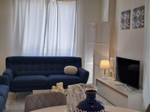 a living room with a blue couch and a tv at Noctua Valle Romano Golf Estepona 003 in Estepona