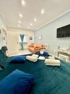 a large blue bed with pillows in a living room at Gloves Rooms in Naples