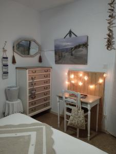 a bedroom with a desk and a dresser with lights at CHAMBRES D'HÔTES CHEZ CATHERINE A REUS chambre bord de mer avec salle de bains privée in Reus