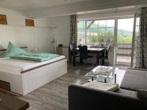 1 dormitorio con cama, mesa y sofá en Ferienhaus Abtsroda en Abtsroda