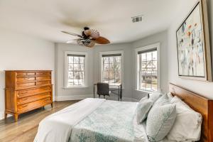 a bedroom with a bed and a dresser and windows at Long Branch Getaway - Walk to Beaches and Dining! in Long Branch