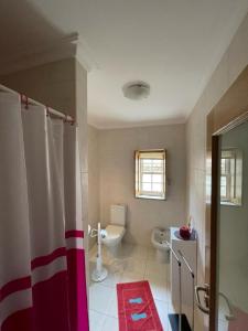 a bathroom with a shower curtain and a toilet at Cantinho da Estrela in Seia +91 photos