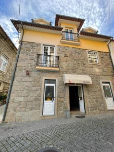 a stone building with a door and a balcony at Cantinho da Estrela in Seia