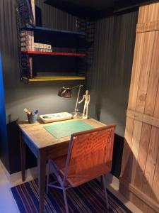 a wooden desk with a lamp and a chair at la petite maison Normandie in Saint-Cyr-du-Bailleul +32 photos