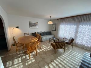 ein Wohnzimmer mit einem Tisch und einem Sofa in der Unterkunft Apartment Corfou in Crans-Montana