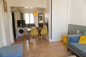 ein Wohnzimmer mit einem Sofa, einem Tisch und Stühlen in der Unterkunft Family' appart Narbonne Centre-ville Clim Wi-fi 2 chambres in Narbonne