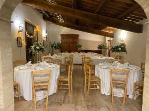 uma sala com mesas e cadeiras com toalhas de mesa brancas em CASALE SUL CLITUNNO em Foligno