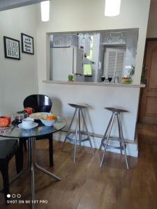 a kitchen with a table and two bar stools at Ipanema Flat in Rio de Janeiro