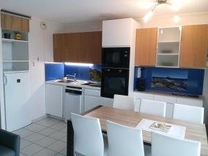 a kitchen with a wooden table and white cabinets at appart 6 pers vue mer classé 3* in Saint-Raphaël