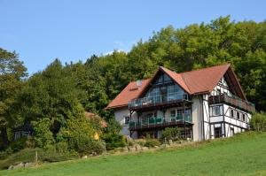 a large house with a red roof on a hill at Ferienhaus Abtsroda in Abtsroda