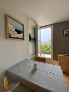 een eetkamer met een tafel en een raam bij Studio avec vue sur la Major in Marseille