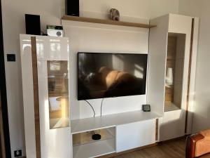 a flat screen tv in a white entertainment center at Apartament Chrobry in Kętrzyn