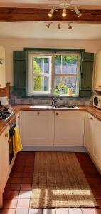 a kitchen with a sink and a window at Vale View Cottages -The Coach House in Prestatyn