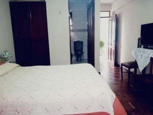 a bedroom with a bed and a desk and a chair at Hostal España in Sucre