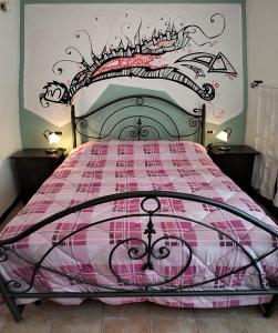 a bedroom with a bed with a plaid bedspread at B&B Sanpancrazio in Vale