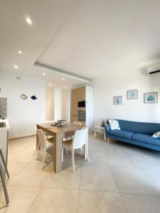a living room with a table and a blue couch at STELLA MARINA VACATION in Pozzallo