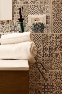 a bathroom with a sink and towels on a wall at STELLA MARINA VACATION in Pozzallo