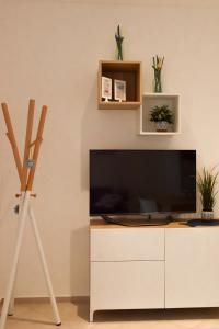 a living room with a television on a white cabinet at STELLA MARINA VACATION in Pozzallo