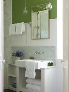 uma casa de banho com lavatório, espelho e toalhas em Gregans Castle Hotel em Ballyvaughan