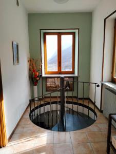 a room with a window and a spiral staircase at B&B Sanpancrazio in Vale