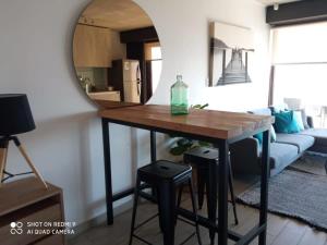 uma mesa numa sala de estar com um espelho em HOM I TOP1 NUEVO STUDIO en mejor zona Valparaíso Parking em Valparaíso