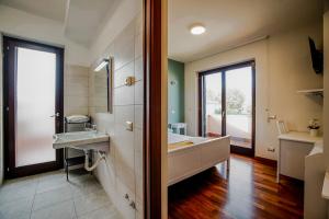 baño con bañera grande y lavamanos en SIGIS HOTEL Fiumicino, en Fiumicino