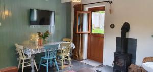 a dining room with a table and a wood stove at Vale View Cottages -The Coach House in Prestatyn