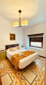 a large bedroom with a large bed and a chandelier at Hotel 3* La Casona de las Flores in Ondara