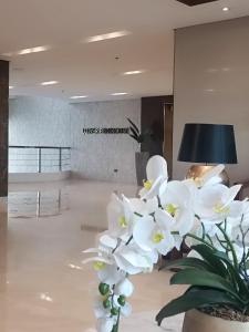 een vaas gevuld met witte bloemen in een lobby bij SMDC Coast Residences near PICC World Trade Center MOA in Manilla