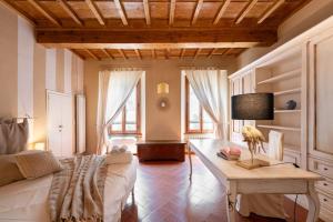 una stanza con un letto e un tavolo con una lampada di Keys of Italy - Ghibellina 80 Big - Trilo comodo e ampio a Firenze