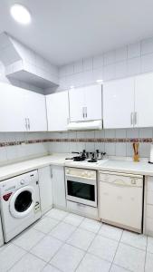 a white kitchen with a stove and a dishwasher at Beautiful 3BR villa with Self-Check-in near to Major Events Family only in Jeddah