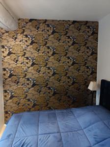 Un dormitorio con una cama azul y una pared en Un temps pour soi, en Serrières