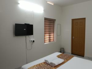 a white room with a bed with towels on it at Greenview Royal Stay Near Amrita Hospital Edappally in Cochin