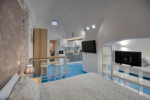 Un dormitorio con una cama y una cocina con barra. en La dimora di Lunatiello, en Atrani
