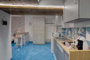 a kitchen with blue floors and white cabinets at La dimora di Lunatiello in Atrani