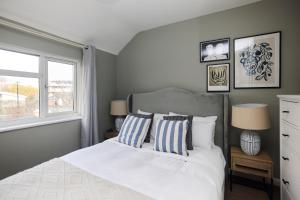 ein Schlafzimmer mit einem weißen Bett und einem Fenster in der Unterkunft The Dagenham Park Place - Dazzling 3BDR House with Garden in Dagenham