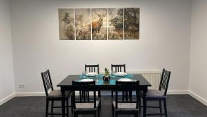 a dining room table with four chairs and a painting at Gästehaus Moorblick in Osten +9 photos