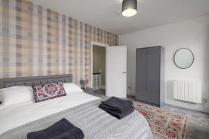 Inviting House near Skewen Park في Skewen: غرفة نوم مع سرير ومرآة على الحائط